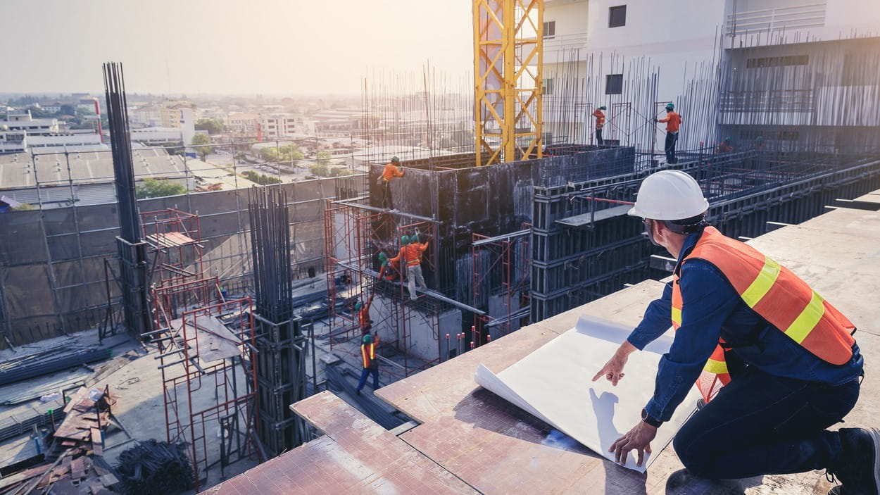 Ingeniør inspiserer tegninger på byggeprosjekt.